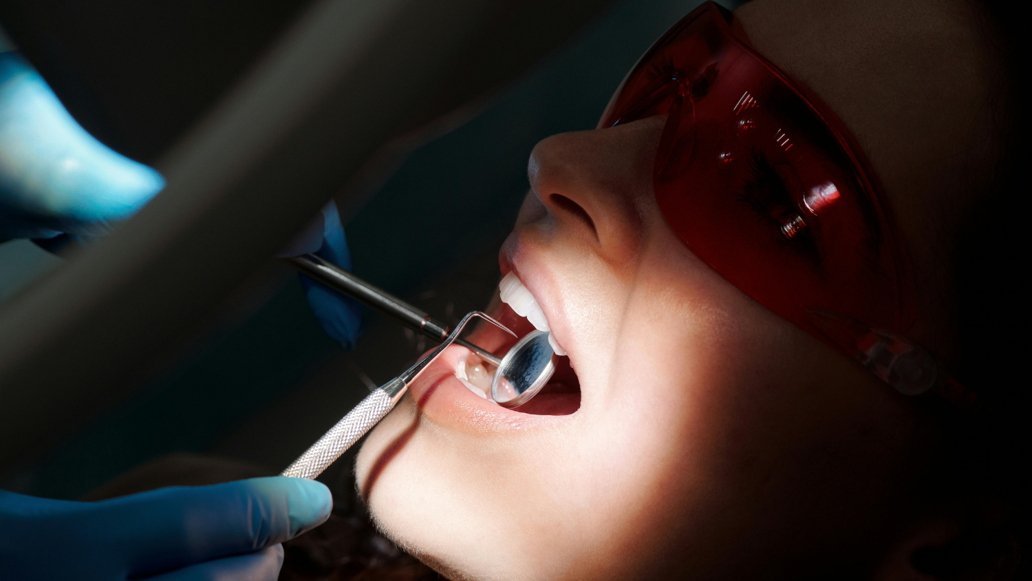 Pacjentka podczas badania stomatologicznego w gabinecie dentystycznym, dentysta sprawdza stan jej dziąseł i zębów.Pacjentka podczas badania stomatologicznego w gabinecie dentystycznym, dentysta sprawdza stan jej dziąseł i zębów.
